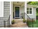 Inviting front porch features brick steps, a navy door with wreath, and seasonal flower pots at 1774 Timmons Marie Ln, Lincolnton, NC 28092