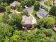 This aerial view showcases the backyard with lush trees, a well-kept lawn, a patio, and the home's exterior at 2103 Lytton Ln, Matthews, NC 28104