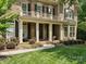 Inviting front porch with classic columns, rocking chairs, and beautiful landscaping at 2103 Lytton Ln, Matthews, NC 28104