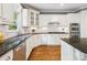 Bright kitchen featuring white cabinets, stainless steel appliances, granite countertops, and hardwood floors at 2103 Lytton Ln, Matthews, NC 28104