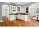 A corner kitchen features white cabinets, granite countertops, stainless steel appliances, and hardwood floors at 2103 Lytton Ln, Matthews, NC 28104