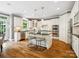 Bright kitchen featuring white cabinetry, an island with bar seating, stainless steel appliances, and hardwood flooring at 2103 Lytton Ln, Matthews, NC 28104