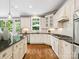 Bright kitchen featuring white cabinets, stainless steel appliances, an island, and hardwood floors at 2103 Lytton Ln, Matthews, NC 28104