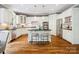 Bright kitchen with white cabinetry, an island with bar seating, stainless steel appliances, and hardwood flooring at 2103 Lytton Ln, Matthews, NC 28104