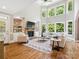 Spacious living room with hardwood floors, a stone fireplace, and large windows for natural light at 2103 Lytton Ln, Matthews, NC 28104