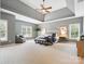 Expansive primary bedroom features tray ceilings, large windows, and a comfortable seating area at 2103 Lytton Ln, Matthews, NC 28104