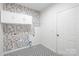 Well-lit laundry room with overhead cabinets, patterned flooring, and modern fixtures at 2316 Savannah Hills Dr, Matthews, NC 28105