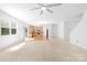 Open-concept living room flowing into the kitchen, featuring a ceiling fan and access to the backyard at 2316 Savannah Hills Dr, Matthews, NC 28105