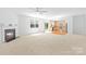 Spacious living room with a fireplace, ceiling fan, and an adjacent kitchen area at 2316 Savannah Hills Dr, Matthews, NC 28105