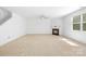 Bright living room with a fireplace, ceiling fan, and a large window providing ample natural light at 2316 Savannah Hills Dr, Matthews, NC 28105