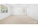 Bright, neutral living room with large windows and plush carpeting throughout at 2316 Savannah Hills Dr, Matthews, NC 28105