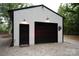Exterior of a modern metal garage with a black door and minimalist design at 2418 Shuford Rd, Lincolnton, NC 28092