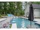 Inviting pool with cascading waterfall features, lounge chairs, and a shaded seating area for outdoor relaxation at 2418 Shuford Rd, Lincolnton, NC 28092