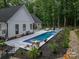 Stylish outdoor pool with lounge seating, elegant landscaping, and stone accents, perfect for relaxation and entertaining at 2418 Shuford Rd, Lincolnton, NC 28092