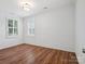 Bedroom with hardwood floors, white wall paneling, and natural lighting at 2656 Polo Club Blvd, Matthews, NC 28105