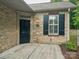 Close-up of a stone exterior home showcasing a stylish front door and trimmed landscaping at 2656 Polo Club Blvd, Matthews, NC 28105