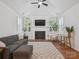 Bright living room with fireplace, large windows, ceiling fan and hardwood floors at 2656 Polo Club Blvd, Matthews, NC 28105