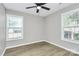 This bedroom offers natural light through two large windows and a ceiling fan at 3853 Carl Parmer Dr, Harrisburg, NC 28075
