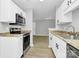 Modern kitchen boasts stainless steel appliances, white cabinets, and granite countertops at 3853 Carl Parmer Dr, Harrisburg, NC 28075