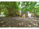 Home backyard with a patio area, lush greenery, and mature trees at 5008 Brooktree Dr, Charlotte, NC 28208