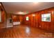 Spacious basement with wood paneling, built-in shelving, and a window for natural light at 5008 Brooktree Dr, Charlotte, NC 28208