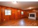 Basement featuring wood paneling, laminate flooring, and a cozy brick fireplace at 5008 Brooktree Dr, Charlotte, NC 28208