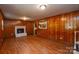 Finished basement features wood paneling, laminate floors, and a brick fireplace at 5008 Brooktree Dr, Charlotte, NC 28208