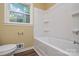 Cozy bathroom with wood-look flooring and a white bathtub and toilet at 5008 Brooktree Dr, Charlotte, NC 28208