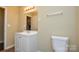 This cozy bathroom features a single vanity, toilet, and mirror at 5008 Brooktree Dr, Charlotte, NC 28208
