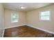 This cozy bedroom features hardwood floors and natural light from two windows at 5008 Brooktree Dr, Charlotte, NC 28208