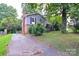 View of the home with a side driveway and mature trees providing shade at 5008 Brooktree Dr, Charlotte, NC 28208