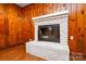 Close up of a white brick fireplace with a black metal door at 5008 Brooktree Dr, Charlotte, NC 28208
