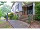 The front porch area is elevated with brick steps and a black iron railing at 5008 Brooktree Dr, Charlotte, NC 28208