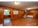 Spacious living room with hardwood floors, wood paneling, and staircase at 5008 Brooktree Dr, Charlotte, NC 28208