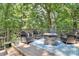 Back deck featuring wood burning fire pit and outdoor seating surrounded by mature trees at 8500 Peyton Randolph Dr, Charlotte, NC 28277