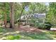 Charming home with dormer windows nestled amongst mature trees and beautiful landscaping at 8500 Peyton Randolph Dr, Charlotte, NC 28277