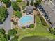 Aerial view of a community pool, surrounded by lounge chairs, greenery, and a nearby pond at 9136 Four Mile Creek Rd, Charlotte, NC 28277