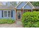 Charming blue home with brick accents and a welcoming front entrance and landscaping at 9136 Four Mile Creek Rd, Charlotte, NC 28277