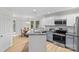 Well-lit kitchen features modern appliances, granite countertops, white cabinets, and light wood flooring at 9136 Four Mile Creek Rd, Charlotte, NC 28277