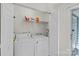 Bright laundry room features washer, dryer, and shelving for storage at 9136 Four Mile Creek Rd, Charlotte, NC 28277