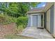 Private patio with sliding glass door access, surrounded by mature shrubs and potted plants at 9136 Four Mile Creek Rd, Charlotte, NC 28277