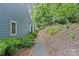 Exterior side yard features a wooded path with lush greenery, offering a private and natural setting at 9136 Four Mile Creek Rd, Charlotte, NC 28277
