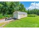 Outbuilding with roll-up door, adjacent to golf cart on green grass at 106 Guffey Rd, Cherryville, NC 28021