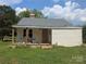 Exterior front view of the home featuring a small porch, boarded up door and windows ready for renovation at 1110 Sulfur Springs Church Rd, Shelby, NC 28152
