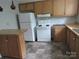 Functional kitchen with white appliances, wood cabinets, and checkered tile floor at 1146 Buffalo St, Shelby, NC 28150