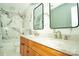 Bathroom with a double sink vanity, stone countertop, and marble-look tile at 12520 Vantage Point Ln, Huntersville, NC 28078