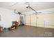 Spacious garage with epoxy floor and modern door opener and lawn equipment at 12520 Vantage Point Ln, Huntersville, NC 28078