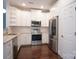 Well-equipped kitchen with stainless steel appliances, white cabinetry, and hardwood flooring at 12520 Vantage Point Ln, Huntersville, NC 28078