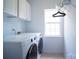 Well-lit laundry room featuring a washer, dryer, and ample storage cabinets at 12520 Vantage Point Ln, Huntersville, NC 28078