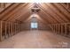 Spacious unfinished attic with exposed rafters and a single window at 1503 Jack White Dr, Rock Hill, SC 29732